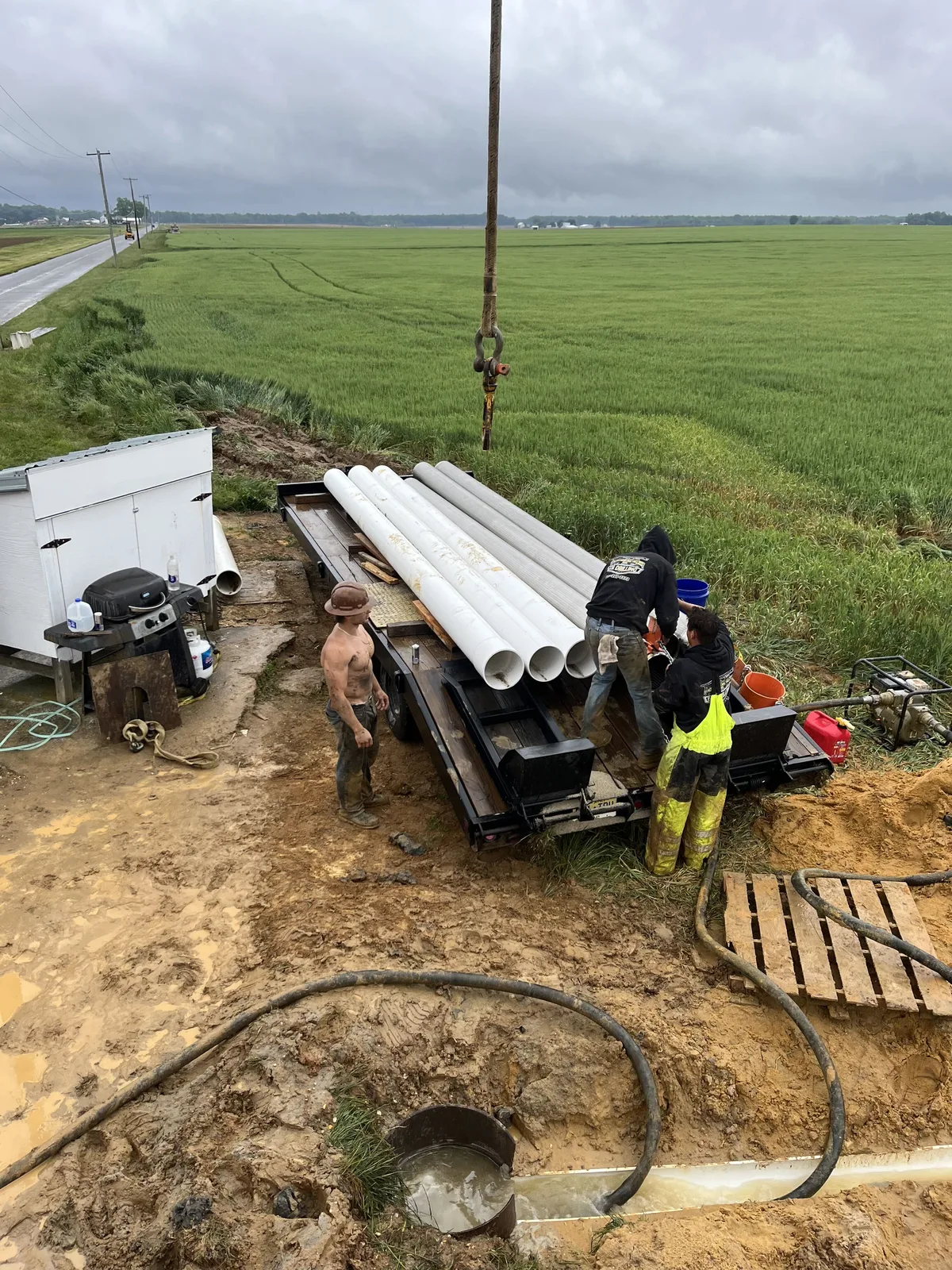 D.N. Drilling crew unloading well casing at a field job